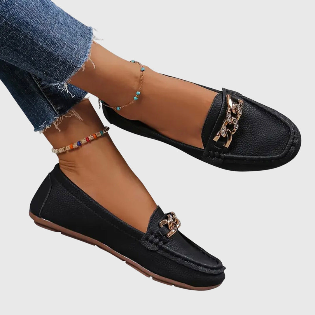 Mocassin femme noir à enfiler avec détail chaîne dorée, vue de profil